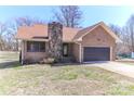 Charming brick home featuring a stone chimney, attached garage and cozy front yard at 2274 Old Wilkesboro Rd, Statesville, NC 28625