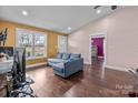 Bright living room with hardwood floors, colorful accent walls, and a comfortable blue sectional sofa at 245 North Dale Ave, Kannapolis, NC 28081