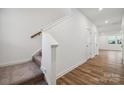 Inviting hallway showcasing wood floors with a carpeted staircase and a crisp, clean white aesthetic at 295 Bezelle Ave, York, SC 29745