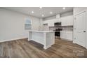 Bright kitchen with stainless steel appliances, white cabinets and island with countertop seating at 302 Bezelle Ave, York, SC 29745