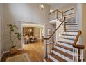 Spacious foyer with hardwood floors, a staircase with wooden handrails, and an elegant dining room beyond at 4219 Kronos Pl, Charlotte, NC 28210