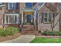 Charming brick home featuring a welcoming front entrance with a columned porch and landscaped garden at 4219 Kronos Pl, Charlotte, NC 28210
