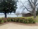 Backyard view with mature trees, lake access, and a small storage shed at 4220 Honeysuckle Rd, Rock Hill, SC 29732