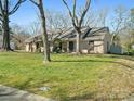 Ranch home featuring a well-kept lawn, mature shade trees, and a brick exterior with a welcoming covered porch at 4631 Dawnridge Dr, Charlotte, NC 28226