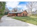 Well-manicured lawn and brick exterior make this home inviting from the circular driveway at 48 Washington Se Ln, Concord, NC 28025