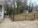 Fenced backyard with a concrete patio, a small storage shed, and mature trees on the border at 534 Fairbluff Ave, Salisbury, NC 28146