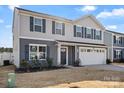 Attractive two-story home with gray siding, well-manicured lawn, and a two-car garage at 668 Pointe Andrews Sw Dr # 93, Concord, NC 28025