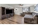 Inviting living room featuring hardwood floors, a cozy sofa, and a built in fireplace and tv stand at 668 Pointe Andrews Sw Dr # 93, Concord, NC 28025