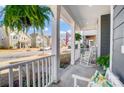 Relaxing front porch with a rocking chair, hanging ferns, and an American flag at 7035 Walnut Branch Ln, Charlotte, NC 28277
