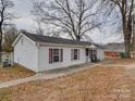 Exterior view of light-sided house with matching trim and a black shingled roof at 709 High St, Albemarle, NC 28001