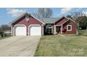 Cozy single-story home featuring a two-car garage and well-manicured front lawn at 7102 Lanark Ct, Charlotte, NC 28217