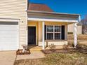 Inviting home exterior with a charming front porch, a manicured garden bed, and a pristine two-car garage at 7220 Hidden Creek Dr, Charlotte, NC 28214