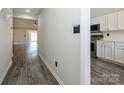 Bright hallway with wood floors leading to an open living space with a modern kitchen, and lots of natural light at 7220 Hidden Creek Dr, Charlotte, NC 28214