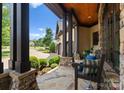 Charming stone front porch featuring stone columns, wood ceilings, a bench, and landscaping at 7461 Barrington Ridge Dr # 33, Indian Land, SC 29707