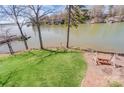 Lush backyard with a swing set overlooks the serene lake, perfect for relaxation at 11 Courageous St, Lake Wylie, SC 29710