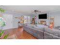 Cozy living room with a brick fireplace, large windows, hardwood floors, and a comfortable gray sofa at 110 Weeping Willow Way, Gastonia, NC 28052