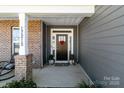 Inviting front entrance with decorative door, brick pillar and comfortable seating at 17215 Monocacy Blvd, Huntersville, NC 28078