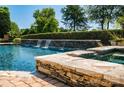 Gorgeous pool area with a waterfall feature and lush greenery at 18302 Town Harbour Rd, Cornelius, NC 28031