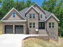 Beautiful, new two-story brick home featuring an attached two-car garage and concrete driveway at 240 Mark Ryan Ln, Dallas, NC 28034