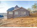 New home with gray brick featuring a well-lit exterior and an unfinished lawn at 240 Mark Ryan Ln, Dallas, NC 28034