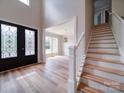 Bright foyer featuring a modern chandelier, hardwood floors, staircase, and a decorative glass door at 240 Mark Ryan Ln, Dallas, NC 28034