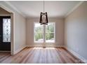 Bright living room featuring a modern chandelier, hardwood floors, and a view of the front yard at 240 Mark Ryan Ln, Dallas, NC 28034