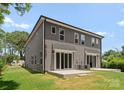 Rear exterior view of a gray duplex with a green lawn and concrete patio areas at 3627 Rogers St, Charlotte, NC 28208