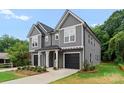 Modern gray duplex with a black roof, manicured lawn, and individual driveways leading to attached garages at 3627 Rogers St, Charlotte, NC 28208