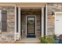 Inviting covered front porch with stone accents, columns and a decorative wreath on the front door at 393 Brannon Meadows Dr, York, SC 29745