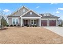 Charming home featuring neutral siding, covered porch, well-manicured lawn, and a three car garage at 4000 Spring Cove Way, Belmont, NC 28012