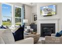 Cozy living room with a fireplace, hardwood floors, large windows, and elegant decor at 4004 Caymen Bay Ct, Tega Cay, SC 29708