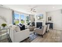 Stylish living room featuring large windows, a fireplace, hardwood floors, and comfortable seating arrangements at 4004 Caymen Bay Ct, Tega Cay, SC 29708