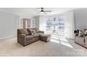 Cozy living room with large windows and a comfortable sofa with ottoman, filled with natural light at 435 Caldwell Se Dr, Concord, NC 28025