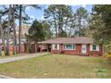 Beautiful brick home with a well-manicured lawn, mature trees, and a convenient carport at 616 W D Ave, Salisbury, NC 28144