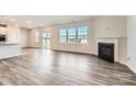 Bright living room showcasing hardwood floors, a cozy fireplace, and sliding glass doors to the backyard at 6265 Fairfax Ct, Maiden, NC 28650