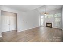 Spacious living room features wood-look floors, a ceiling fan, a vaulted ceiling, and a fireplace at 151 Kallie Loop, Mooresville, NC 28117