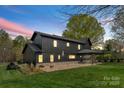 A covered patio and stone landscaping enhances the expansive backyard of this newly built, modern home at 1575 Shinnville Rd, Cleveland, NC 27013