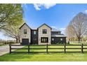 Beautiful home with a stone and black brick facade, a manicured lawn, and a rustic wooden fence at 1575 Shinnville Rd, Cleveland, NC 27013