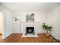Bright living room with a decorative fireplace, hardwood floors, and crisp white walls at 1601 South Point Rd, Belmont, NC 28012