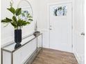 Bright foyer showcasing wood floors, decorative console table, and white trim at 1720 Coral Bark Ln # Kh15, Charlotte, NC 28216