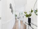 Bright hallway leading to a modern living room with hardwood floors and white furniture at 1720 Coral Bark Ln # Kh15, Charlotte, NC 28216
