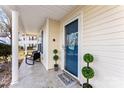 Charming front porch featuring a blue front door, decorative plants, and a comfortable seating area at 1811 Endeavor Ln, Clover, SC 29710