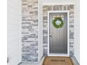 Inviting front entrance with a wreath, a welcome mat, and stone and siding details at 2009 White Cypress Ct # Kh13, Charlotte, NC 28216