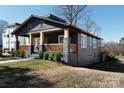 Charming craftsman home featuring a welcoming front porch with wooden railings, and lush landscaping at 236 Victoria Ave, Charlotte, NC 28202