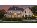 Elegant exterior featuring stone accents, manicured hedges, and a welcoming double-door entry at 2477 Peninsula Shores Ct, Denver, NC 28037