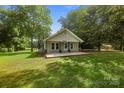 Charming single-story home featuring a welcoming front porch, manicured lawn, and mature trees at 28419 Nc Hwy 73 Hwy, Albemarle, NC 28001