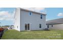 Spacious backyard with lush green grass, a sliding glass door, and a view of the surrounding neighborhood at 3430 Saddlebred Dr, Gastonia, NC 28052