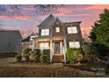 Inviting two-story home with a brick facade, covered porch, and landscaped front yard bathed in twilight hues at 437 Buttermere Rd # 31, Fort Mill, SC 29715