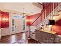 Elegant foyer featuring a staircase, hardwood floors, designer wallpaper and glass front door at 4930 Park Phillips Ct, Charlotte, NC 28210