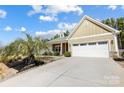 Charming single-Gathering home with a manicured lawn, palm tree, and an attached two-car garage at 5252 Admirals Lndg, Lancaster, SC 29720